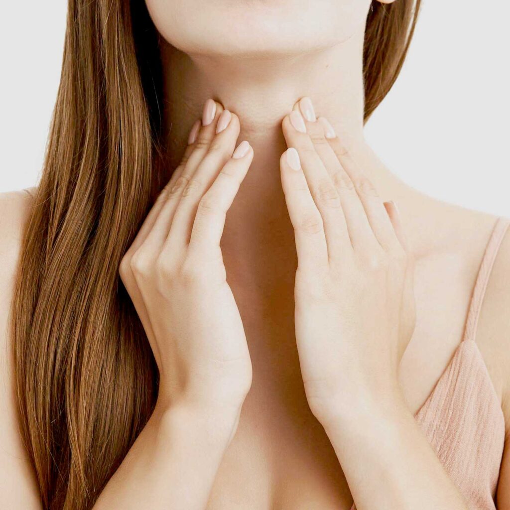 Femme se tient le cou car elle souffre de dysphagie (problèmes de déglutition)