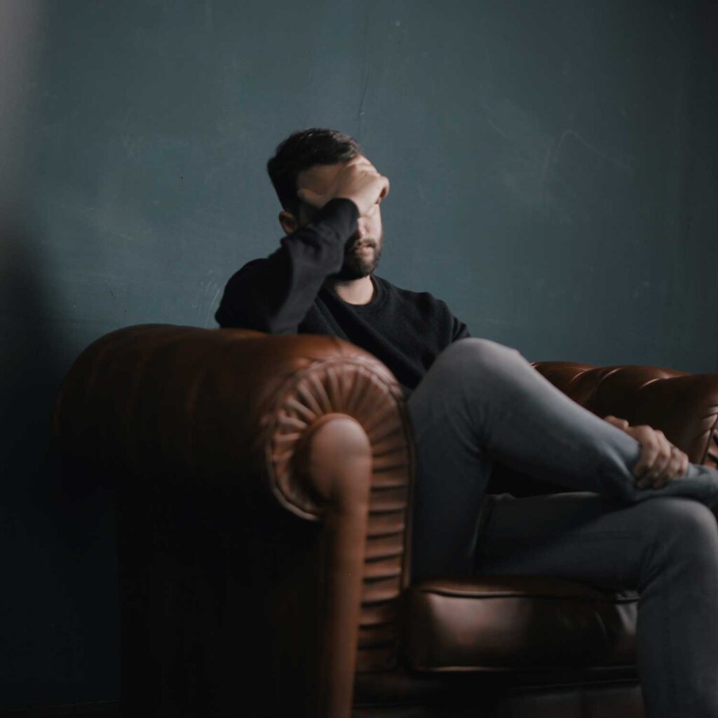 homme se tient la tête de douleur
